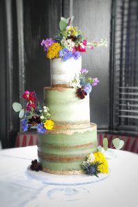 Semi naked green wedding cake with wildflowers